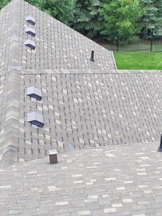New roof shingles and roof vents installed on a house